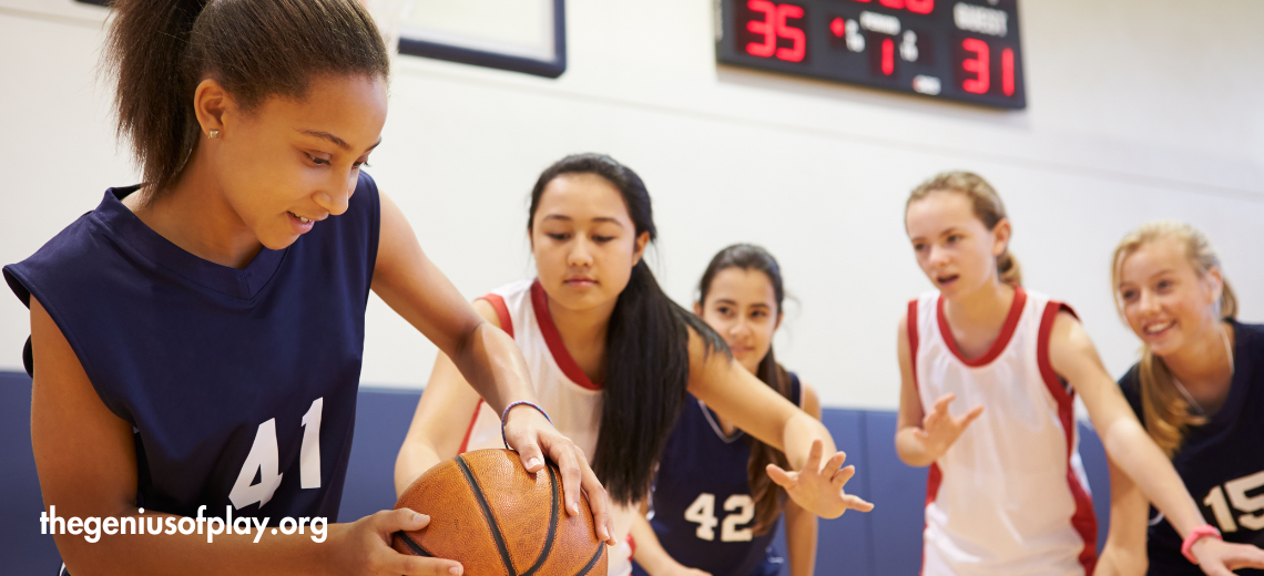 group of adolescent girls playing basketball in a school gym