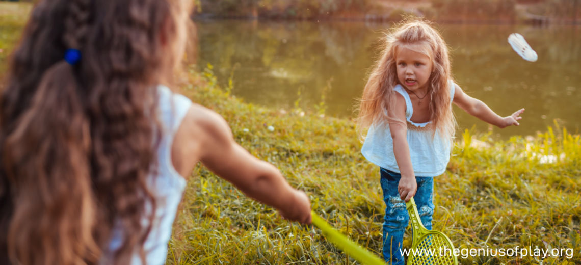 young girls playing badminton outdoors