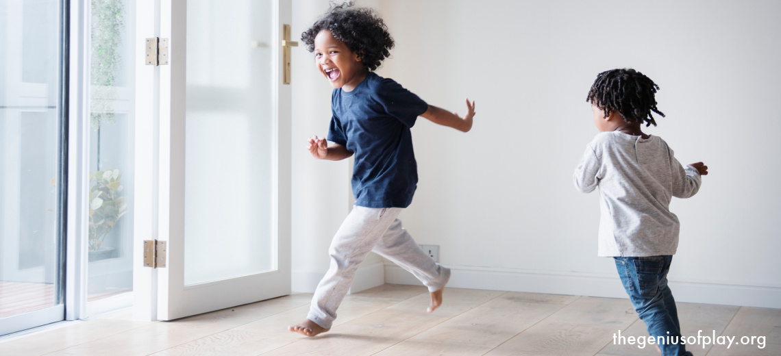 young African American pre-school girls running around and chasing each other indoors